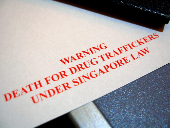 A disembarkation/embarkation form issued by the immigration authorities of Singapore, bearing the statement "WARNING: DEATH FOR DRUG TRAFFICKERS UNDER SINGAPORE LAW"