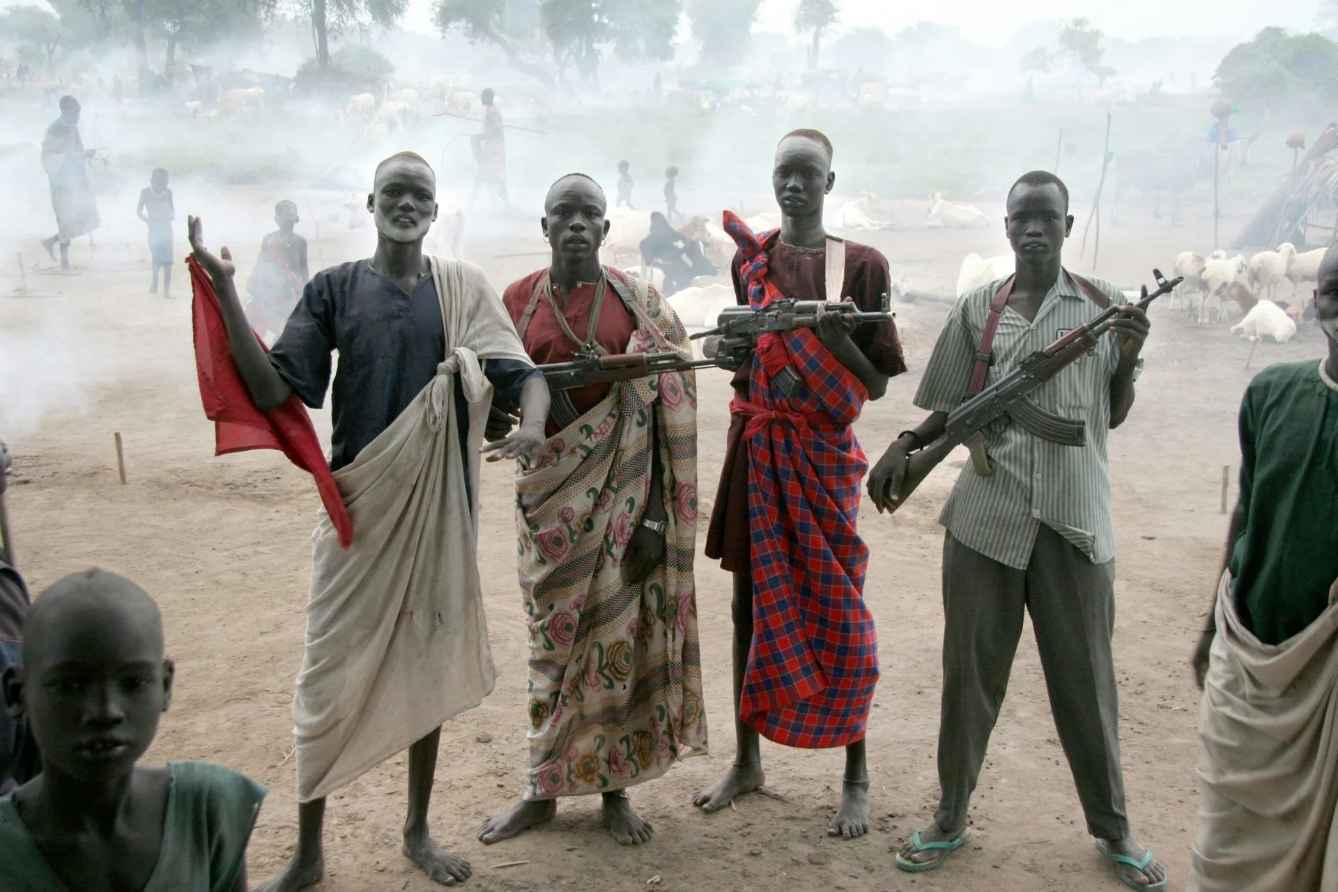 Young men heavily armed in the middle of a village.