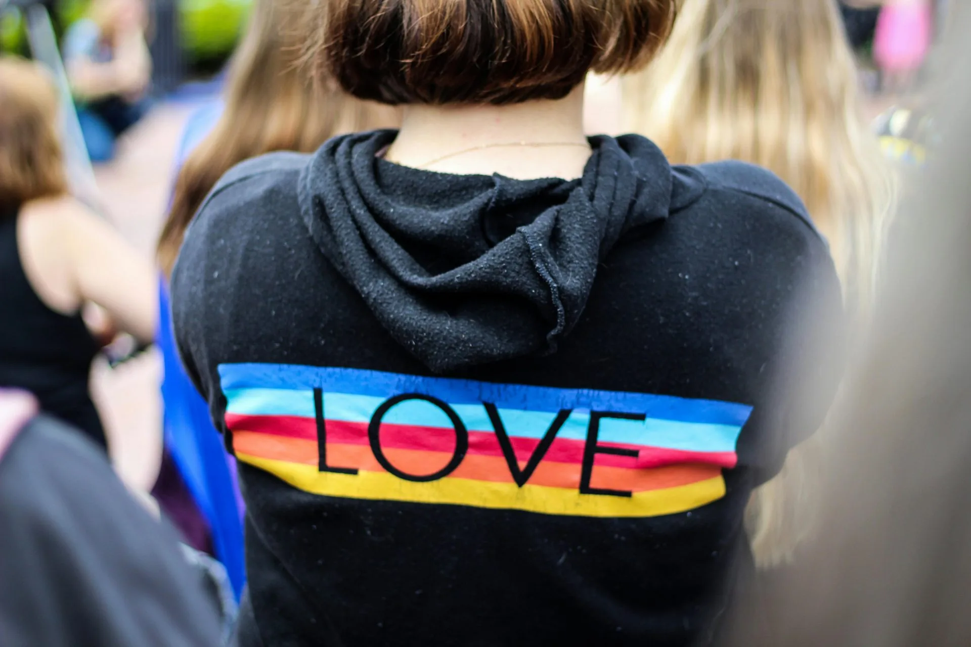 Woman in Black and Multicoloured Love Print Hoodie.