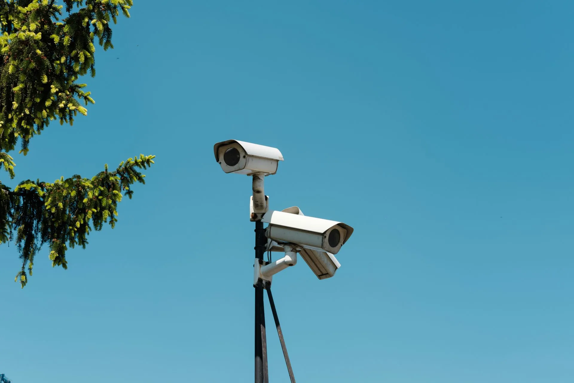 Surveillance camera with blue sky background.