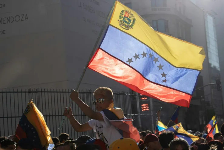 Man in protest holding Venezuela flag